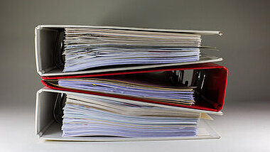 Das Bild zeigt drei Ordner, die übereinander liegen.