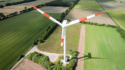 Luftbild mit Windrad von oben und Hintergrundlandschaft