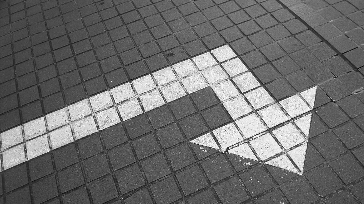 Richtungspfeil auf Straßenpflaster